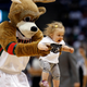 The Milwaukee Bucks mascot carries off the court a young Miami Heat fan after a baby race competition during a time out in Game 4 of the NBA first round playoff series between the Milwaukee Bucks and Miami Heat in Milwaukee, Wisconsin April 28, 2013.
